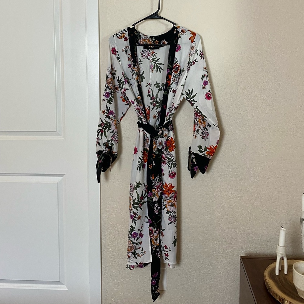 White robe with black trim and floral detail. Good condition